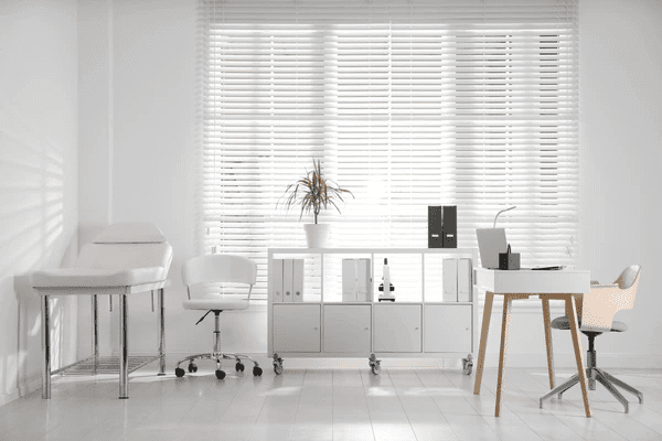 A bright and modern doctor's office in Dubai featuring stylish, modern, and sleek white Venetian blinds, ensuring privacy and light control. Top best blinds window blinds 2025.