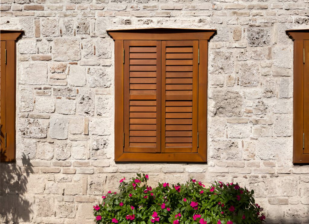 Elegant wooden blinds set against a classic stone wall, offering a unique and timeless style in Dubai’s best window treatment trends for 2025.