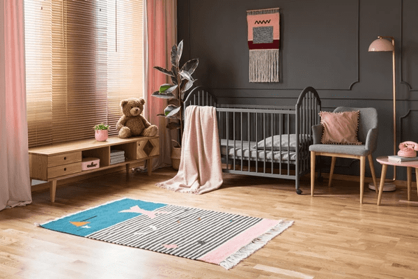 Cozy nursery with soft pink curtains and wooden blinds, offering the best blinds and curtains options in Dubai for 2025.