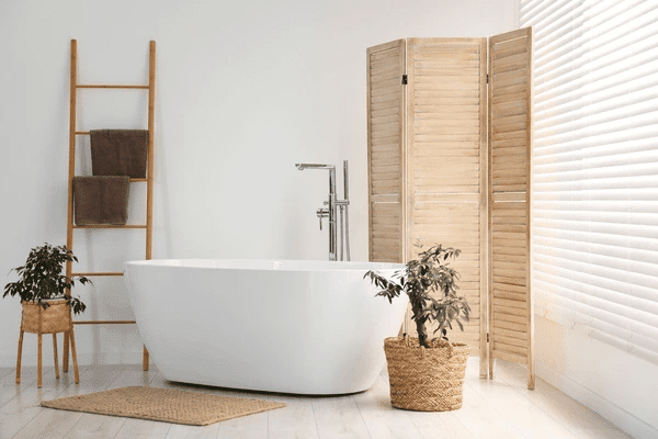 A modern bathroom featuring elegant white window blinds, a freestanding bathtub, and natural wooden décor, creating a sleek and stylish atmosphere.
