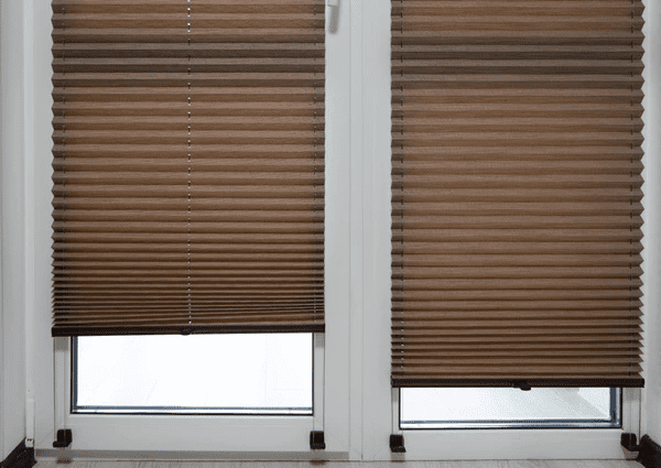 Modern brown pleated blinds on glass doors, offering stylish light control and privacy in Dubai 2025.