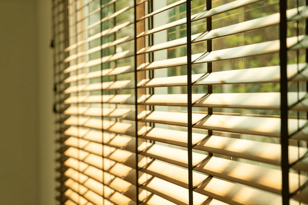 Close-up of a beautifully crafted bamboo blind filtering sunlight, creating a warm and natural ambiance in a modern interior.