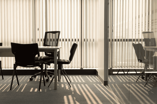 A bright Dubai office with vertical window blinds filtering sunlight, reducing distractions, and improving productivity.