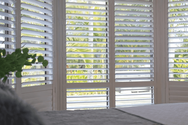 A bright and airy room featuring stylish white plantation shutters, offering a sleek and modern design with adjustable slats for light control and privacy.
