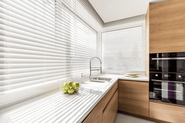 A modern kitchen featuring top-rated white blinds, enhancing natural light while maintaining privacy—perfect for the best kitchen blinds Dubai 2025 collection.