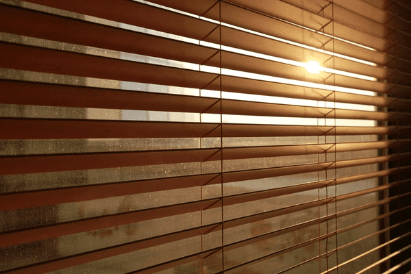 Sunlight streaming through elegant, light-filtering blinds, creating a warm and modern ambiance.
