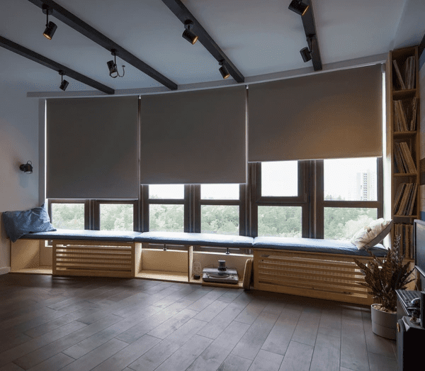 Modern living space with motorized roller shades, providing excellent light control and privacy while enhancing the room’s aesthetic with premium fabric materials.