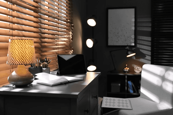A stylish home office with wooden soundproofing blinds, a sleek desk, warm lighting, and modern décor, creating a peaceful and productive workspace.
