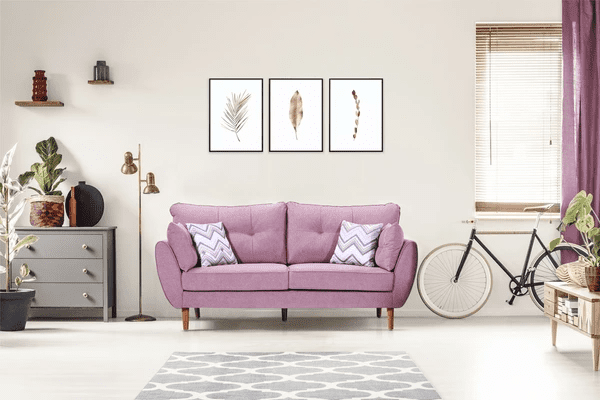 A stylish living room featuring modern wooden blinds, a pastel purple sofa, a bicycle, and elegant wall art, creating a sleek and luxurious ambiance.