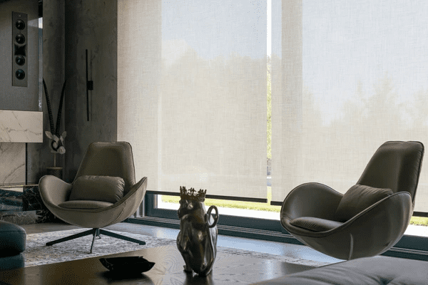 A stylish modern living room with motorized blinds in Dubai, offering an elegant and energy-efficient window covering solution.