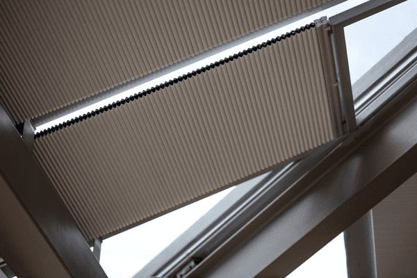 Motorized pleated blinds 2025 installed on a roof window, offering an affordable and cheap smart shading solution for modern homes.