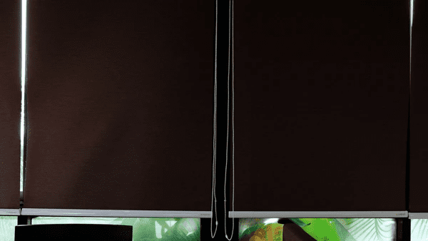 A pair of dark blackout blinds covering a window, blocking sunlight while ensuring privacy in a modern Dubai home.