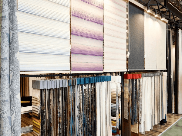 Fabric blinds and curtain samples neatly arranged in a stylish Dubai shop offering discounted and trendy home solutions.