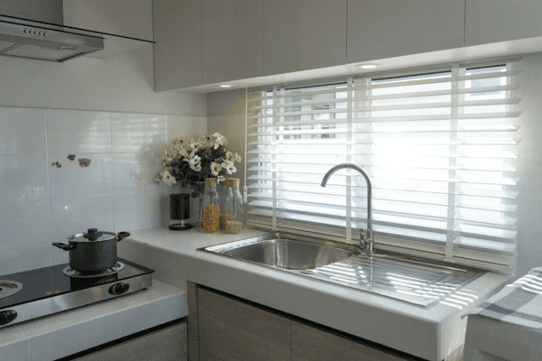 Dubai kitchen 2025 with white horizontal blinds, stainless steel sink, neutral-toned cabinets, and soft overhead lighting for a modern vibe.