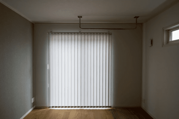 Empty room in Dubai featuring minimalist white vertical long blinds with wooden flooring and neutral walls