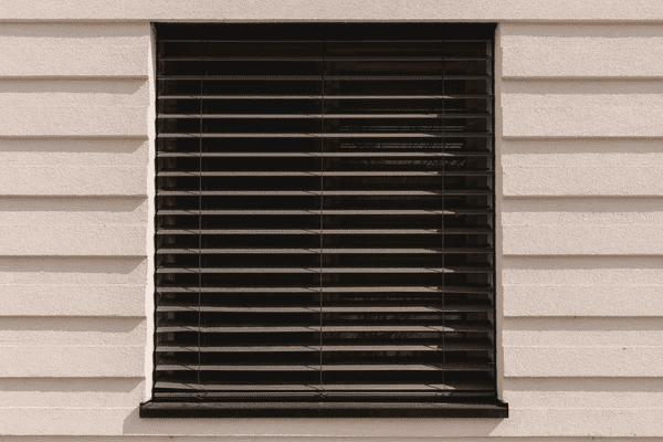 Modern black horizontal outdoor blinds on a minimalist cream-colored wall in Dubai.