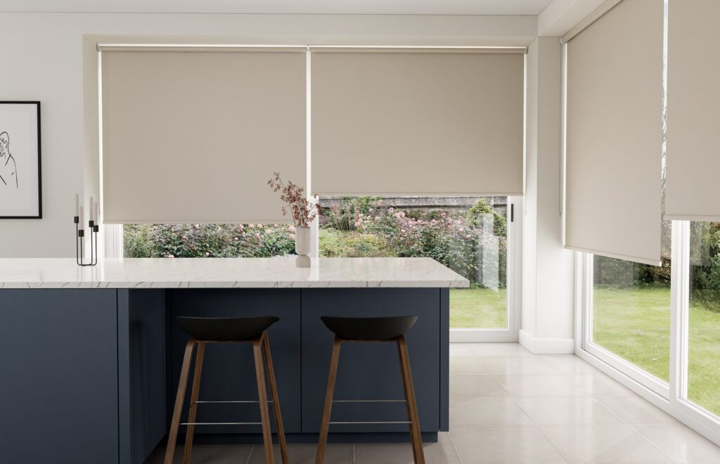  Bright kitchen area with large patio doors covered by elegant cream-colored roller blinds.