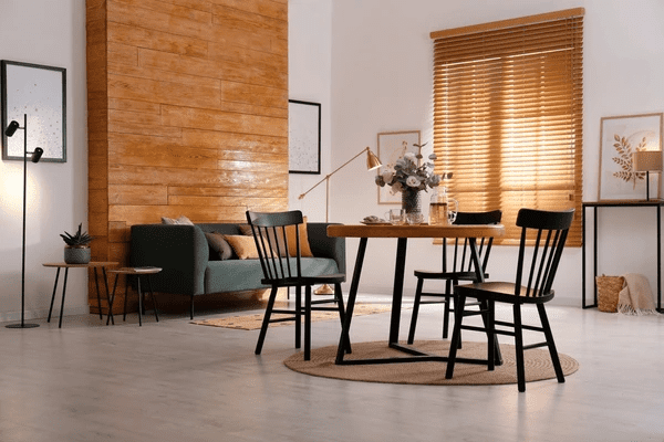 A stylish dining room with wooden blinds, a modern table set, warm lighting, and elegant decor, creating a cozy yet luxurious home atmosphere.