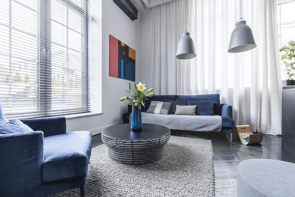 Contemporary Dubai living room with soundproof blinds, blue furniture, and cozy modern interior