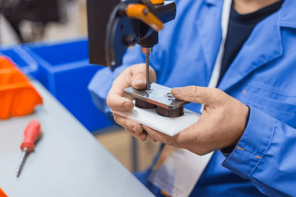 Worker assembling a component for motorized blinds, showcasing precise craftsmanship in Dubai's 2025 luxury blinds market.