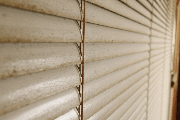 Close-up view of dirty blinds highlighting the importance of maintenance and quality materials for luxurious blinds in Dubai 2025.