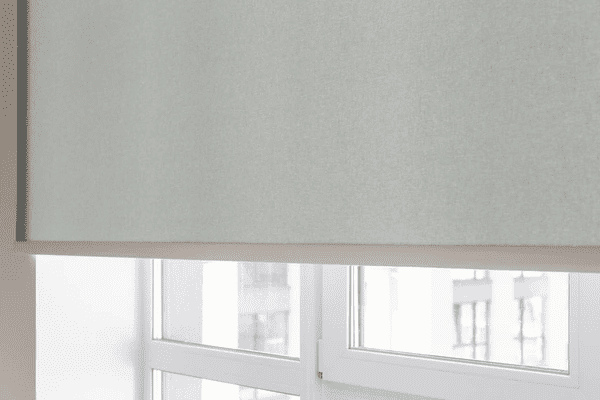Best Long Blinds in Dubai 2025 - Close-up of light gray roller blinds covering a large window, blending luxury with modern design.