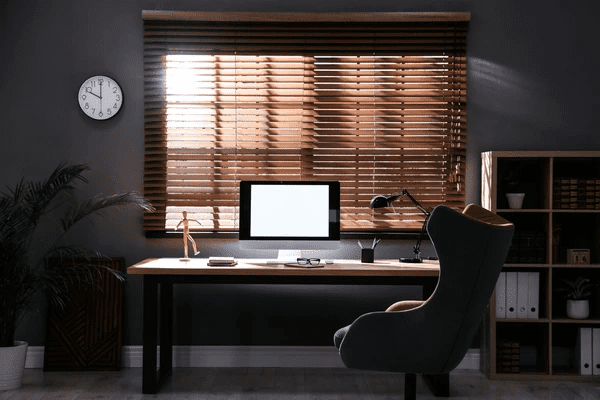 Modern office setup with a computer desk in front of large wooden blinds, creating a luxurious and professional workspace in Dubai 2025.