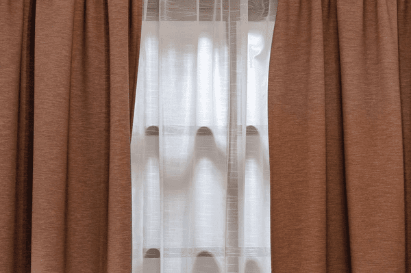 Brown double-layer blackout curtains with sheer white inner lining, designed to retain warmth and enhance privacy.