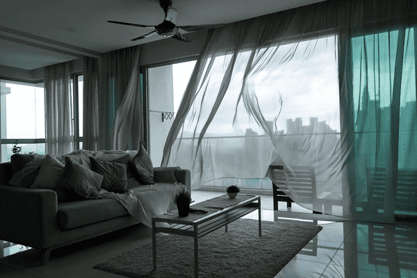 Modern living room with custom-made soundproof blackout curtains, creating a sleek and cozy atmosphere.
