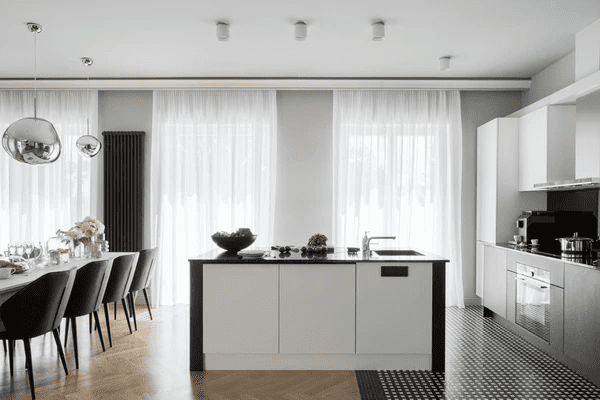 Luxury kitchen and dining space with floor-to-ceiling white acoustic curtains that reduce noise and enhance sleek modern interiors in Dubai 2025.