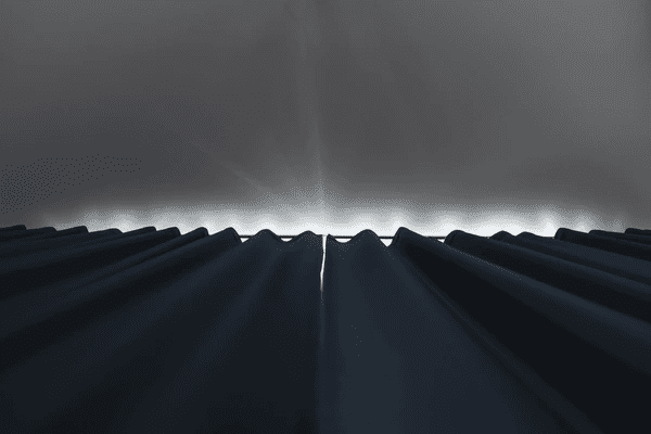  Close-up view of dark blackout curtains fully drawn with minimal light seeping from above, creating a perfect sleep environment.