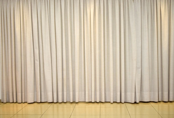 Full-length thick cream-colored winter curtains for large Dubai interiors, offering warmth and minimalist elegance.