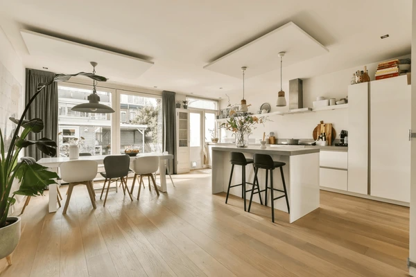 Open-plan Dubai kitchen and dining area with sleek, floor-length grey curtains complementing minimalist decor.