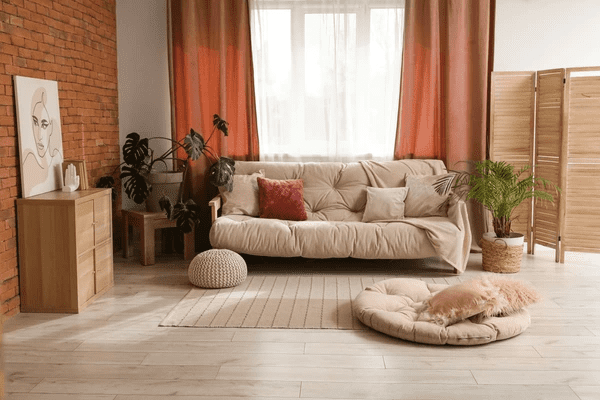 Luxurious peach-red living room curtains in a cozy, modern Dubai apartment with a soft beige sofa and natural wood decor.