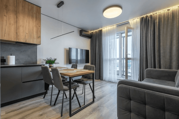 Modern open-plan apartment with sleek gray blackout curtains offering privacy and elegance in a cozy living room.


