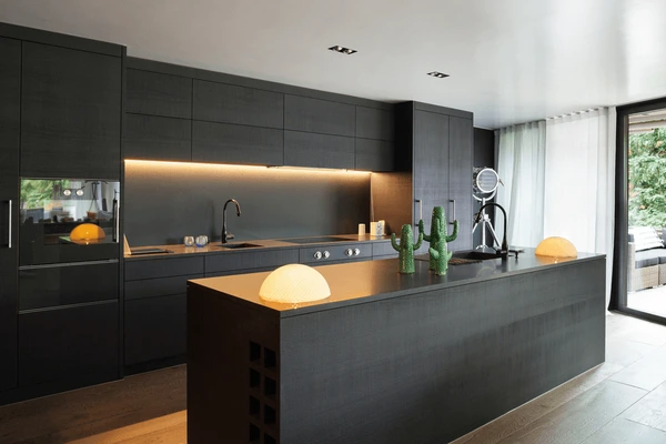 Modern black kitchen in Dubai featuring minimal sheer white curtains, matte cabinetry, and ambient lighting for a sleek and elegant design.

