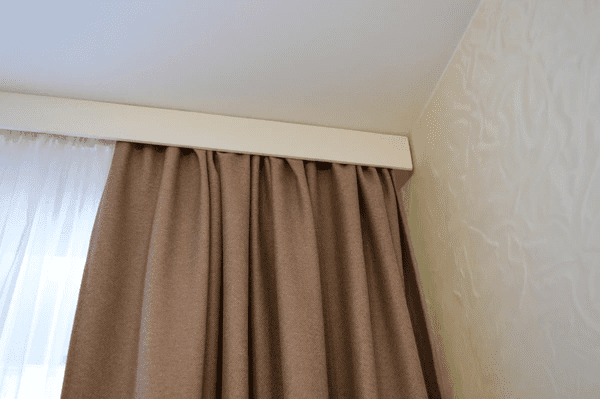 Close-up of sleek brown blackout curtains installed on a ceiling-mounted track in a Dubai home, 2025.

