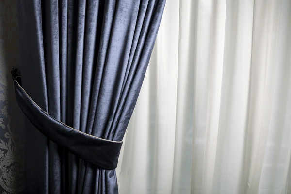 Close-up of elegant dark velvet curtain paired with sheer white drapes in a Dubai home.