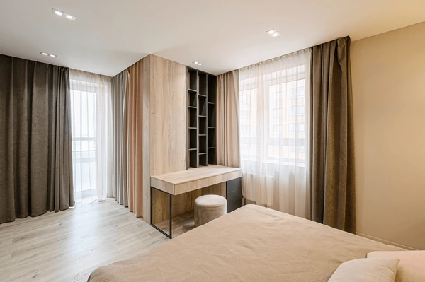 Elegant layered curtains with sheer inner panels and dark outer drapes in a stylish Dubai bedroom.