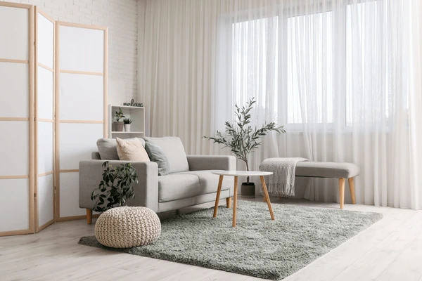 Light-filled living room with sheer white curtains covering the full wall, ideal for modern and cozy Dubai interiors.