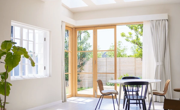 Dubai home interior with white sheer curtains, large glass doors, natural sunlight, and minimal furniture in 2025.