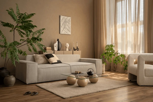 Sunlit cozy living room with earthy tones, sheer beige curtains, modern light furniture, indoor plants, and soft natural textures.