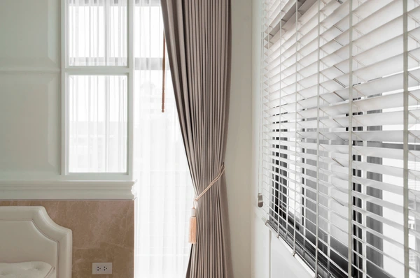 Best Green Wall Curtains in Dubai 2025 featuring elegant beige curtains paired with sheer white drapes and sleek blinds for a luxurious and modern home interior.