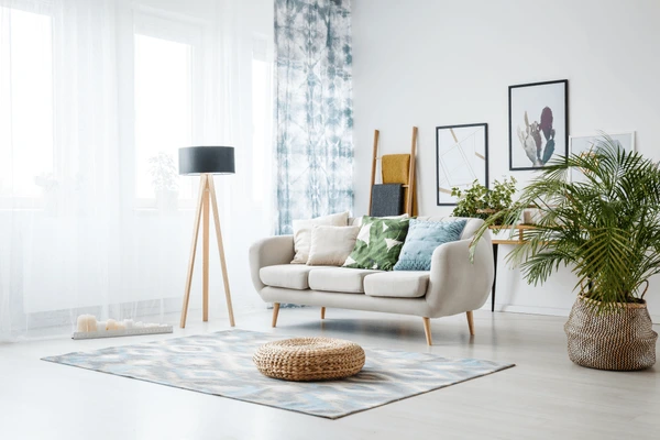 Bright Dubai living room in 2025 featuring patterned blue-white hanging curtains, a beige sofa, and modern décor.