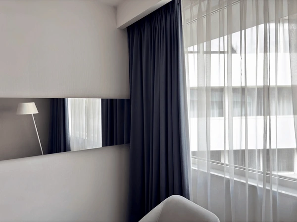 Modern bedroom with elegant Best Blackout Curtains and sheer white drapes, showing hotel-style blackout curtain design for Christmas in Dubai 2025.